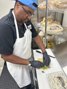 Person wearing apron preparing food in kitchen